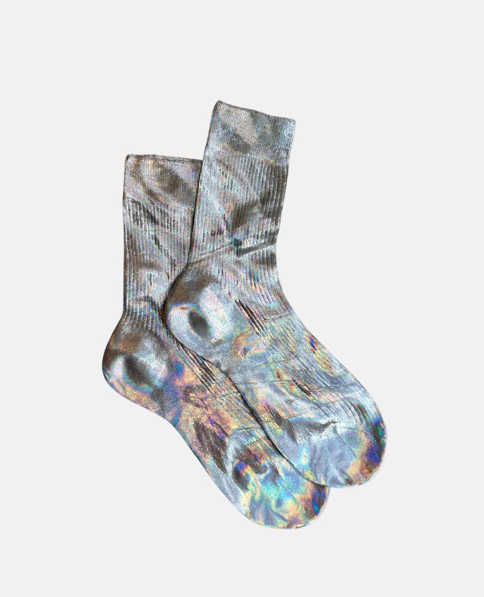 A pair of iridescent socks with a shimmering, multicolored pattern featuring hues of silver, blue, and purple, crafted from a smooth, stretchy fabric with a ribbed texture at the cuffs.