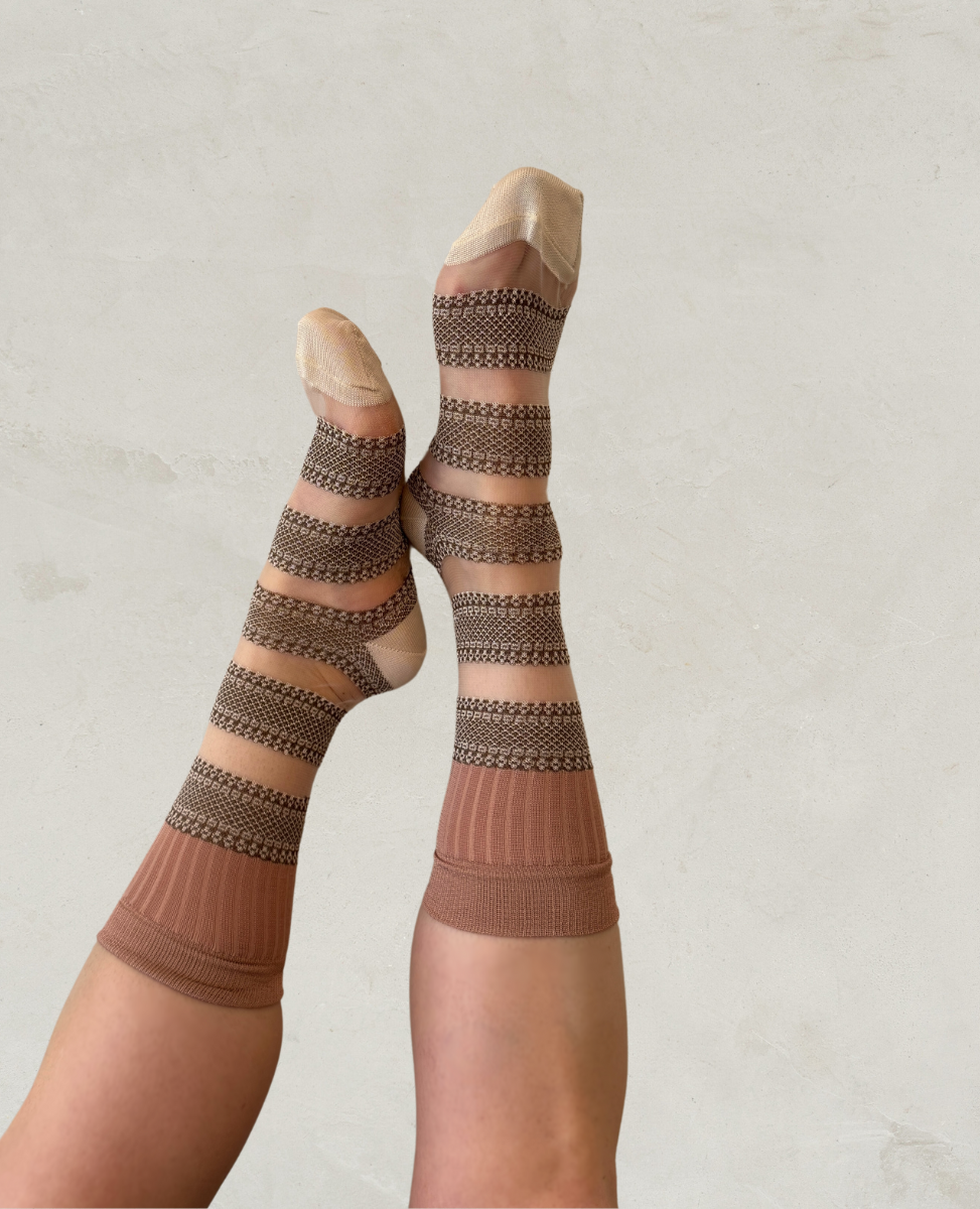 Knee-high socks featuring alternating horizontal stripes of beige and brown with intricate patterns, a ribbed texture at the top, and a smooth, seamless finish at the toes and heels.