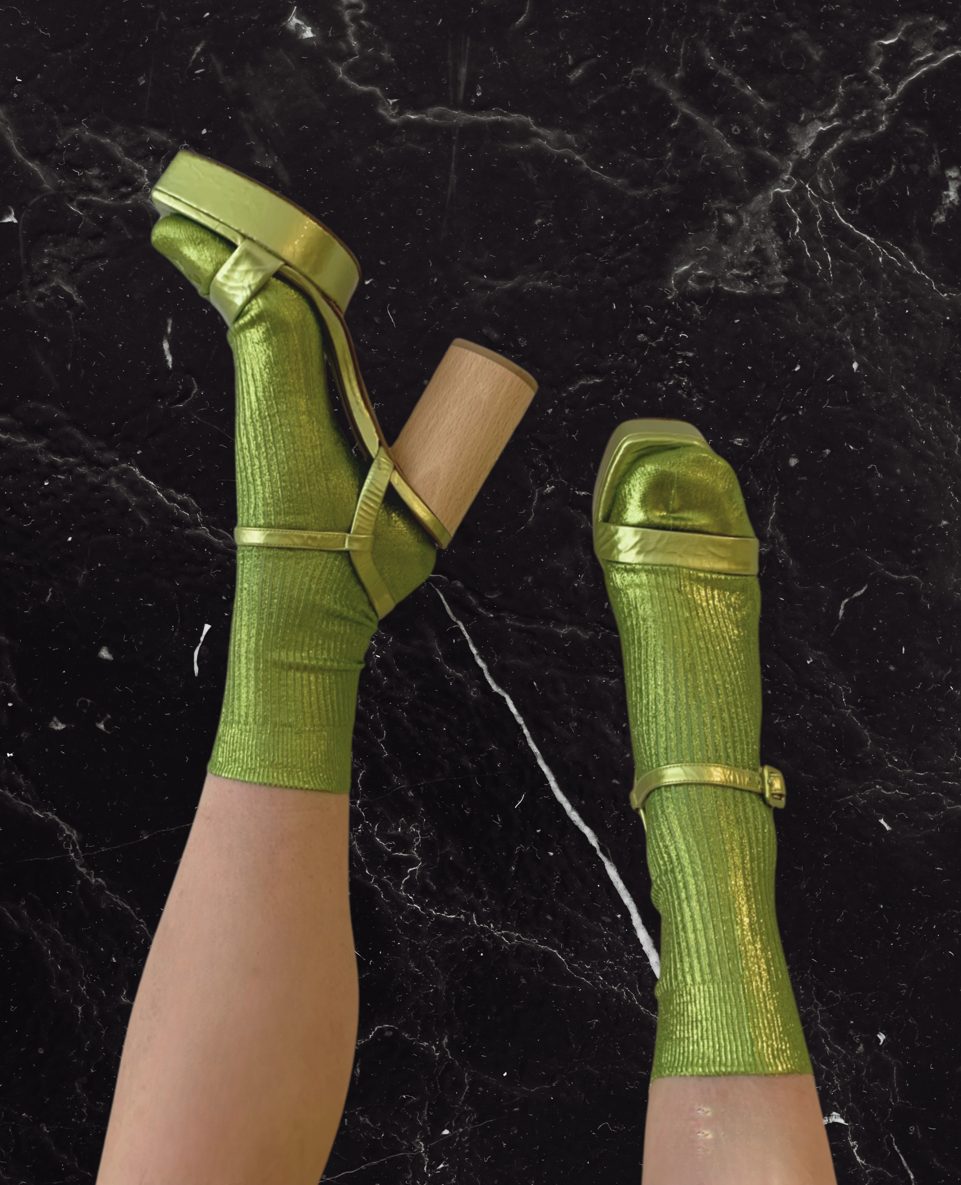 Feet in green socks wearing the Angel Heel against a marble backdrop.