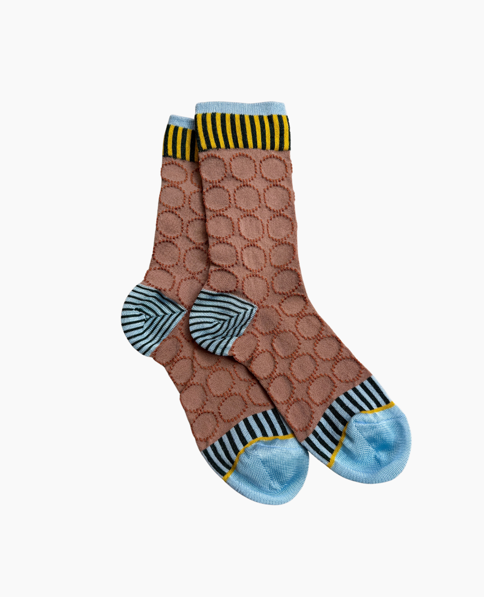 A pair of mid-calf socks featuring a brown base with a raised circular pattern, accented by blue and black striped heels and toes, and a yellow and black striped cuff.