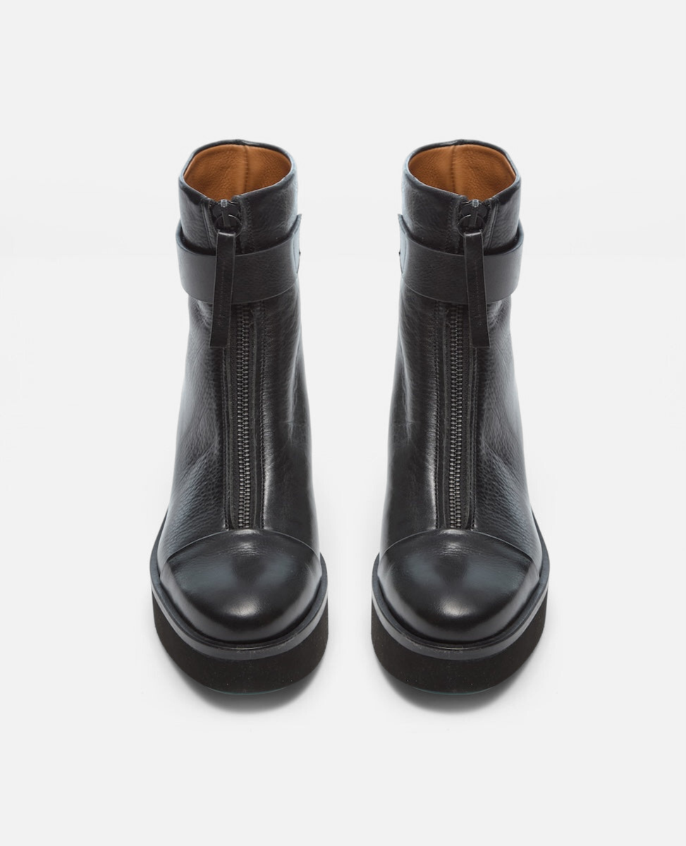 Pair of black leather boots with zipper on a white background