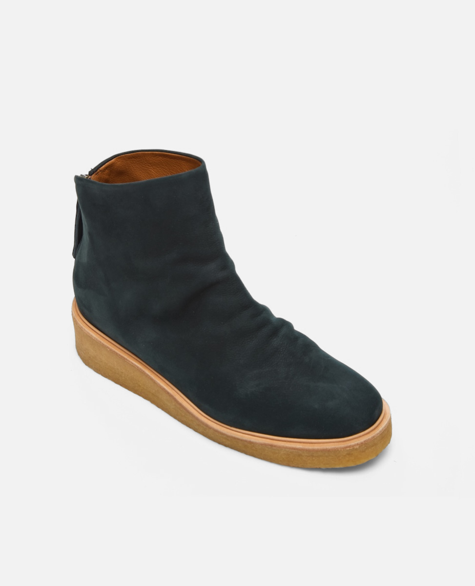 Black ankle boot with brown sole on a white background
