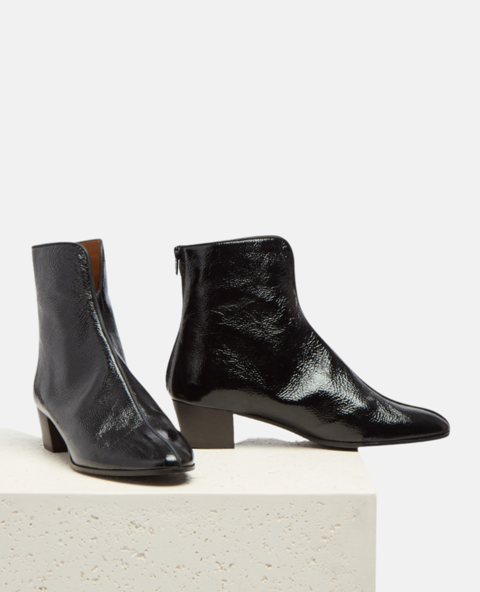 Pair of black leather ankle boots on a light gray background