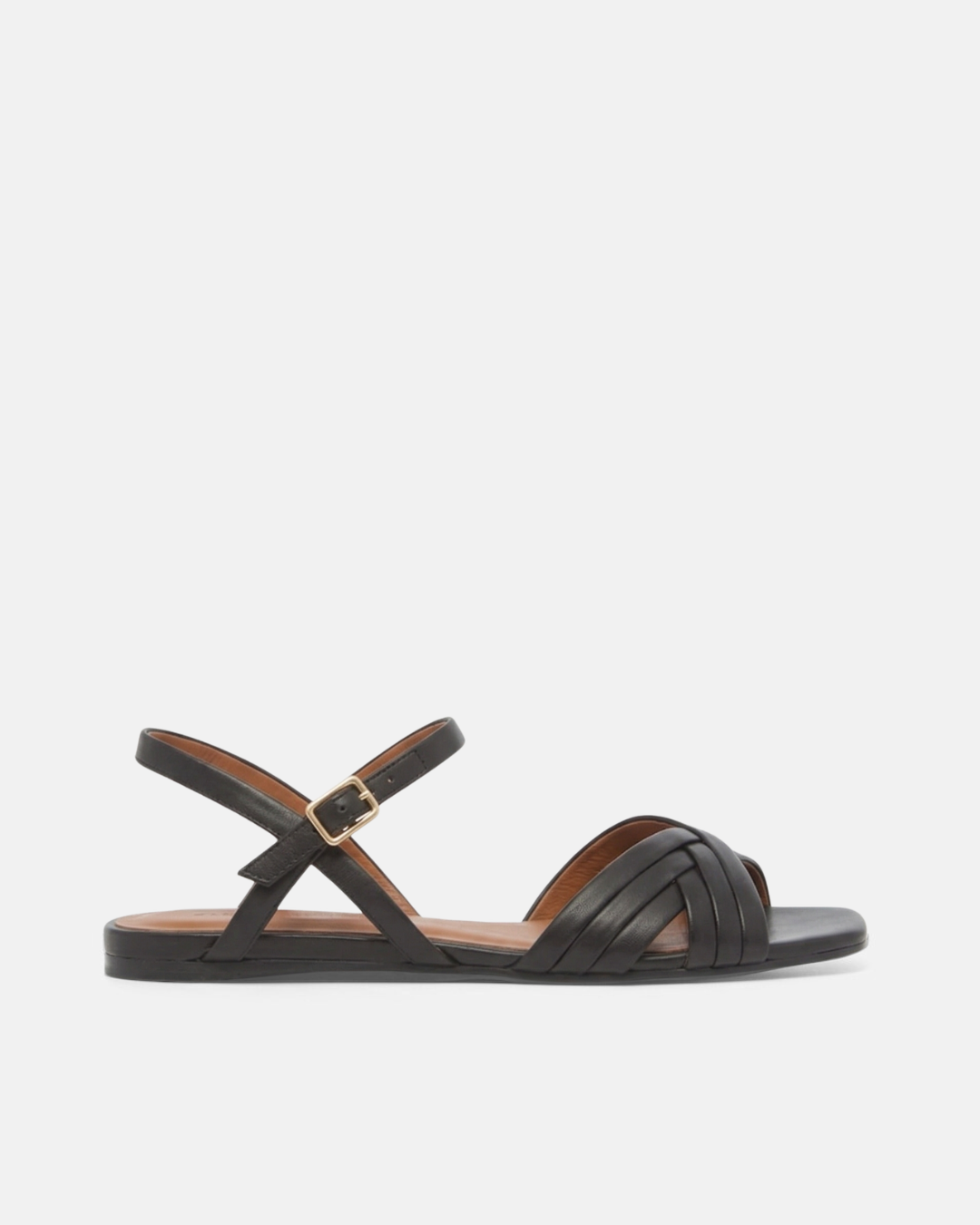 Side view of a black leather flat sandal with slim crisscross toe straps, buckle quarter strap, and square toe, on a pale grey background.