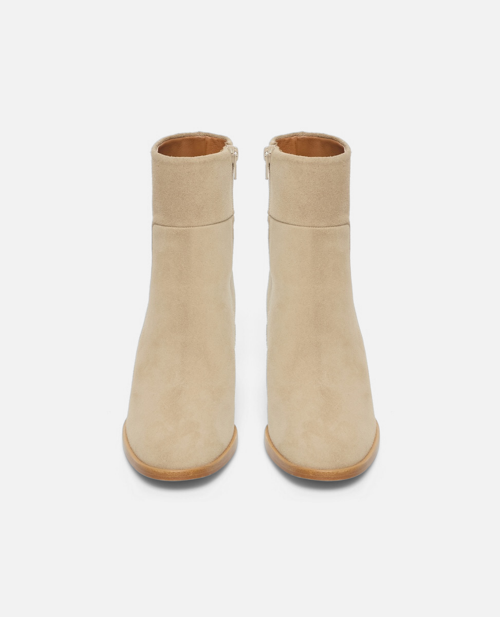 Pair of beige ankle boots on a white background