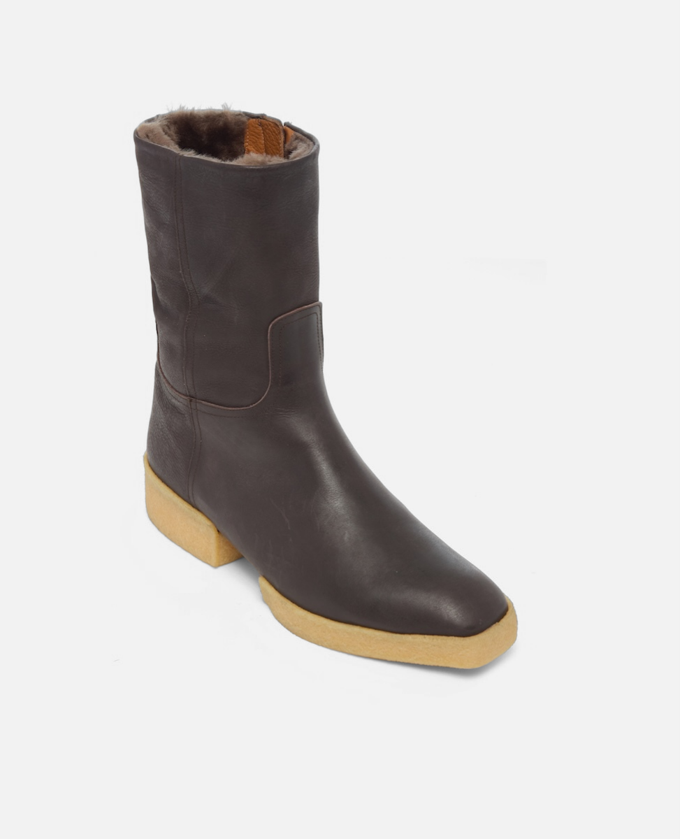 Brown leather boot with a light brown sole on a white background