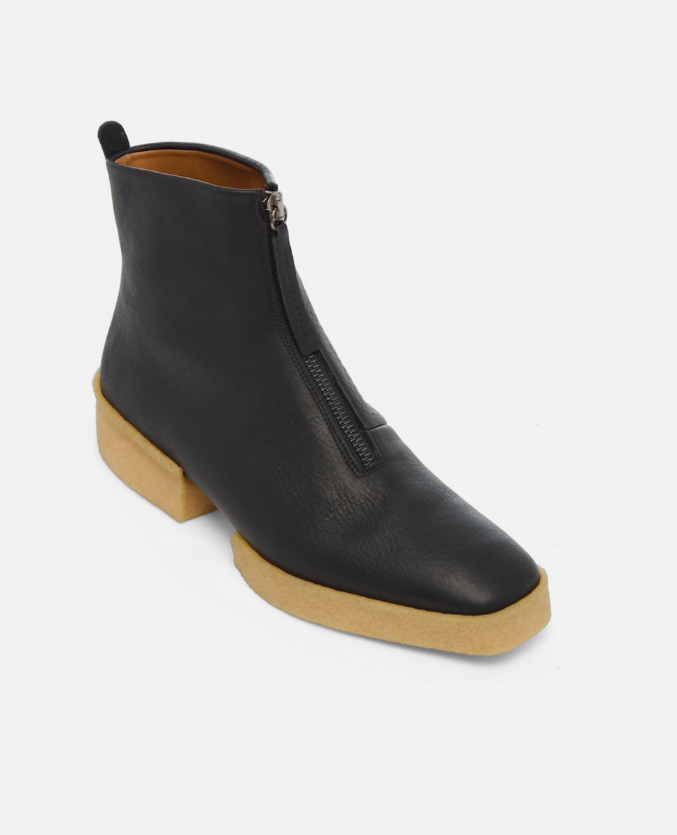Black ankle boot with a wooden sole on a white background
