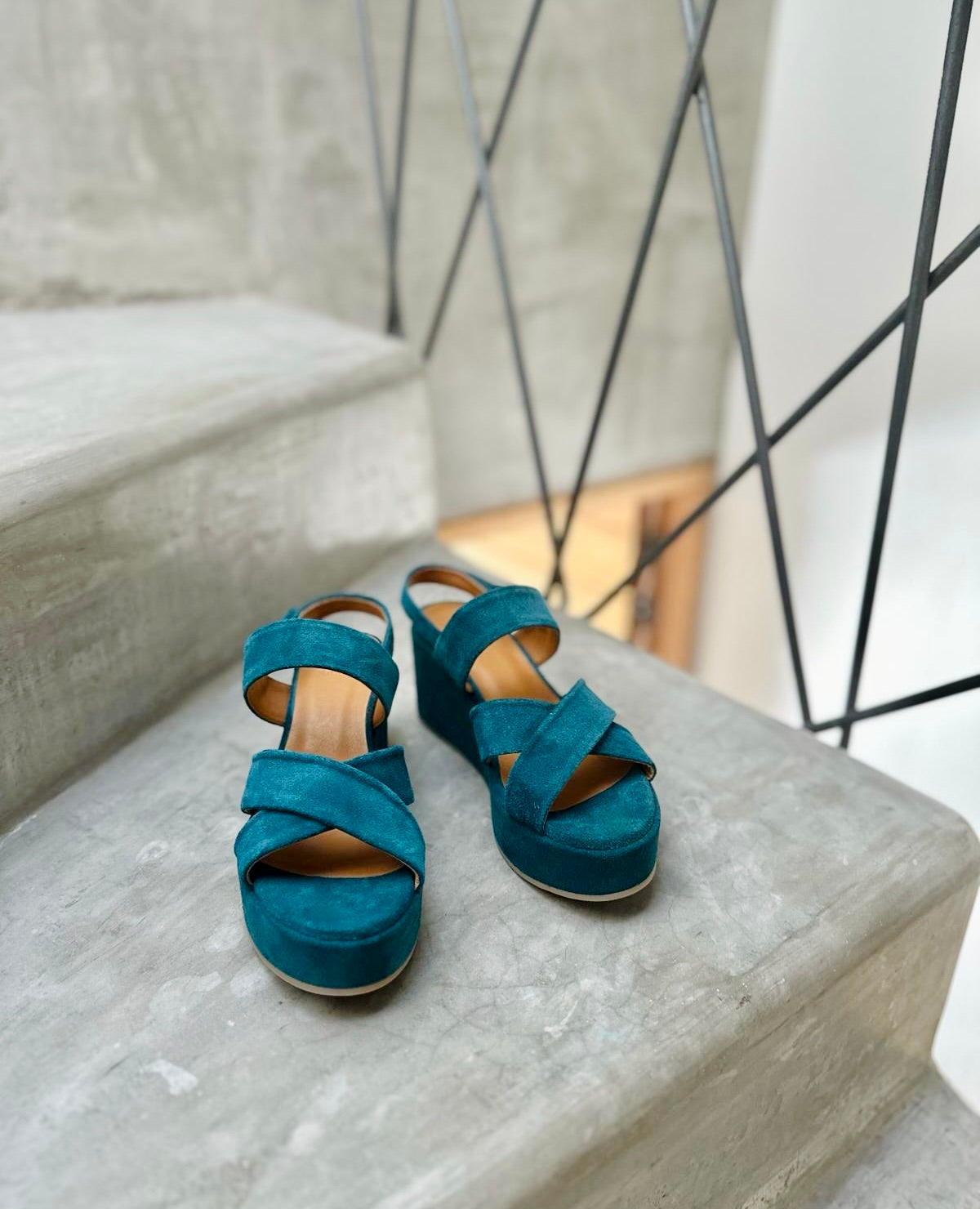 Lacine Wedge sandal in Azure split suede, shown on a staircase