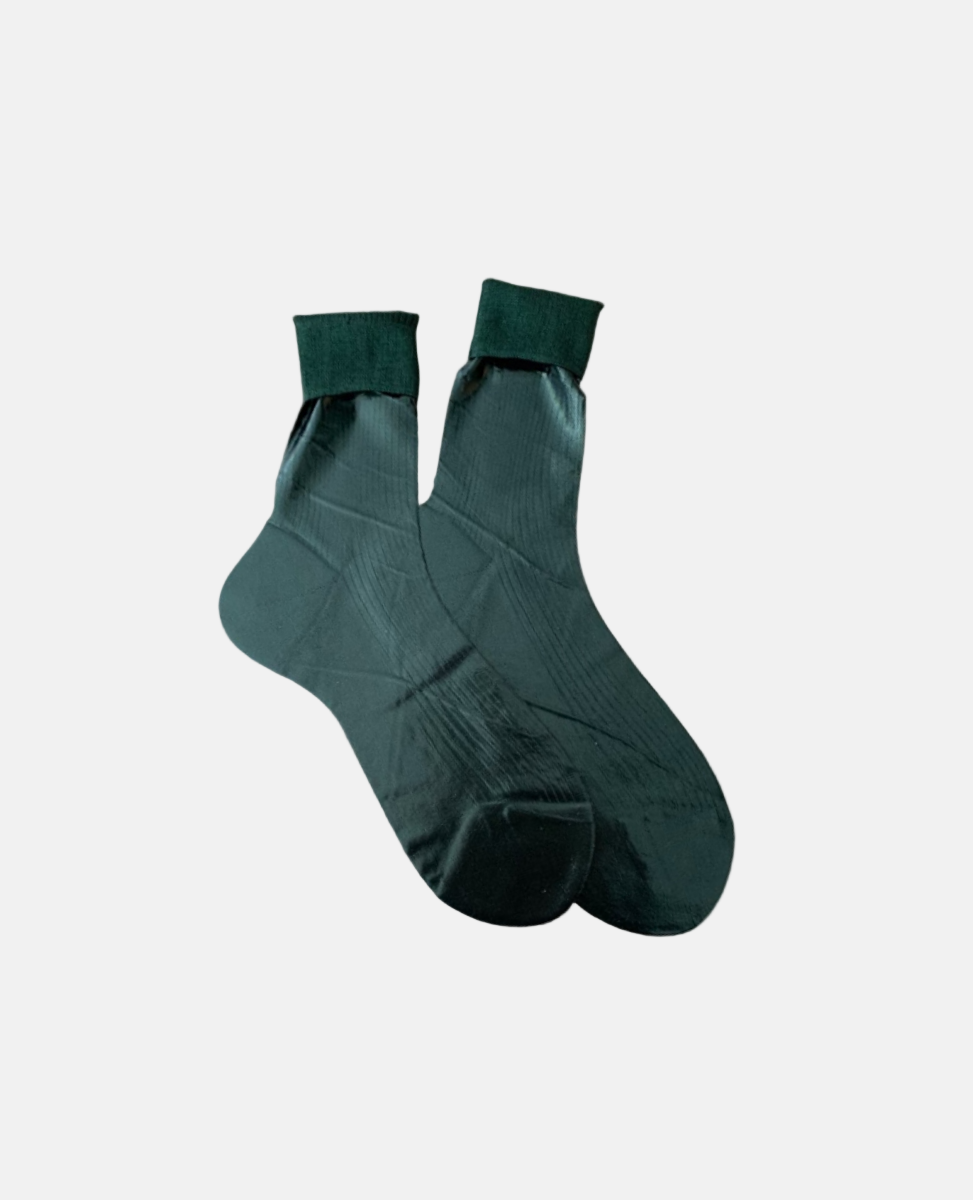 A pair of dark green, mid-calf socks with a smooth, slightly shiny texture, featuring a ribbed cuff and a seamless toe design.