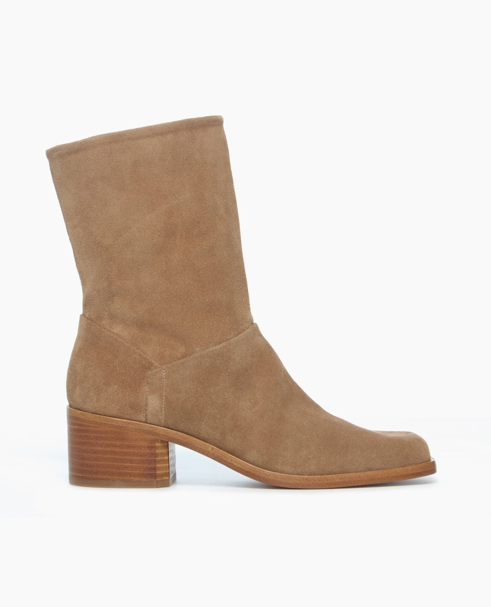 A mid-calf, tan suede boot with a square toe, a stacked block heel, and a smooth, seamless design.