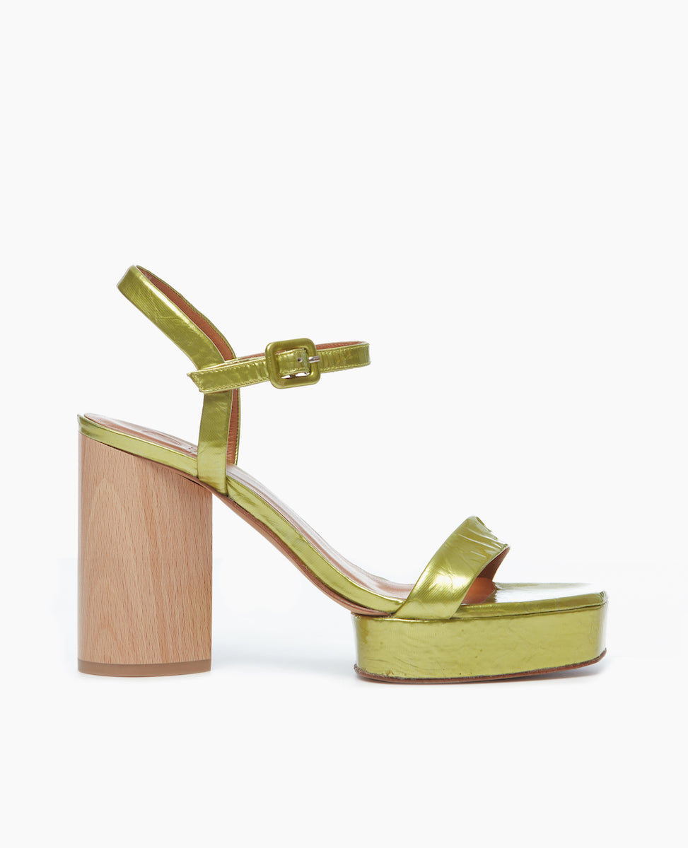 Side view of Angel platform sandal makes a statement in chartreuse patent leather featuring a single strap across the toes is paired with a clean quarter strap and a covered buckle.