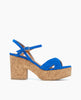 A vibrant blue sandal with a suede-like texture features a thick cork platform heel, an open toe design with crisscross straps, and an adjustable ankle strap with a small buckle. 4