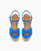 Bright blue sandals with crisscross suede straps, a tan leather insole, adjustable ankle straps, and a cork wedge heel. 6