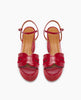 Red high-heeled sandals with a glossy finish, featuring a wide front strap with cut-out details, an adjustable ankle strap, and a tan insole. 4