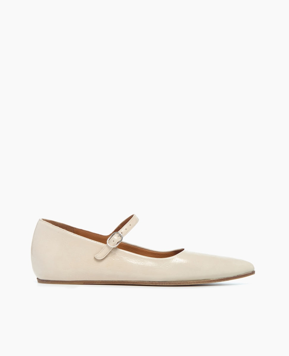 A sleek, cream-colored leather ballet flat with a pointed toe, a thin strap across the instep secured by a small buckle, and a flat sole.