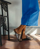 Lower legs covered in a blue dress with feet wearing the Ferhana Sandal in anthracite shimmer suede. 7