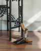 Ferhana Sandal in anthracite shimmer suede with the left sandal propped up against a black night table. 2
