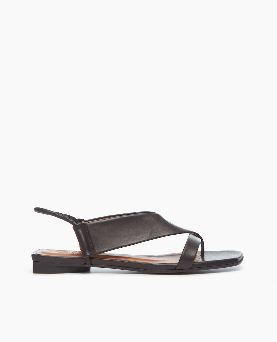 Side view of the Finch Sandal in Black, featuring a wide-strap thong and elasticized leather strap at the heel.