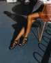 Legs of a woman wearing the Flair Gladiator Sandal in Black. 2