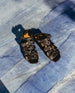 Pair of the Flair Sandal in Black placed on blue marble flooring. 6