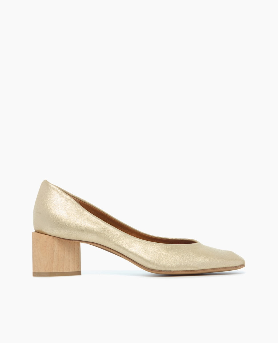 A gold, low-heeled shoe with a smooth, metallic finish, featuring a rounded toe and a wooden block heel.