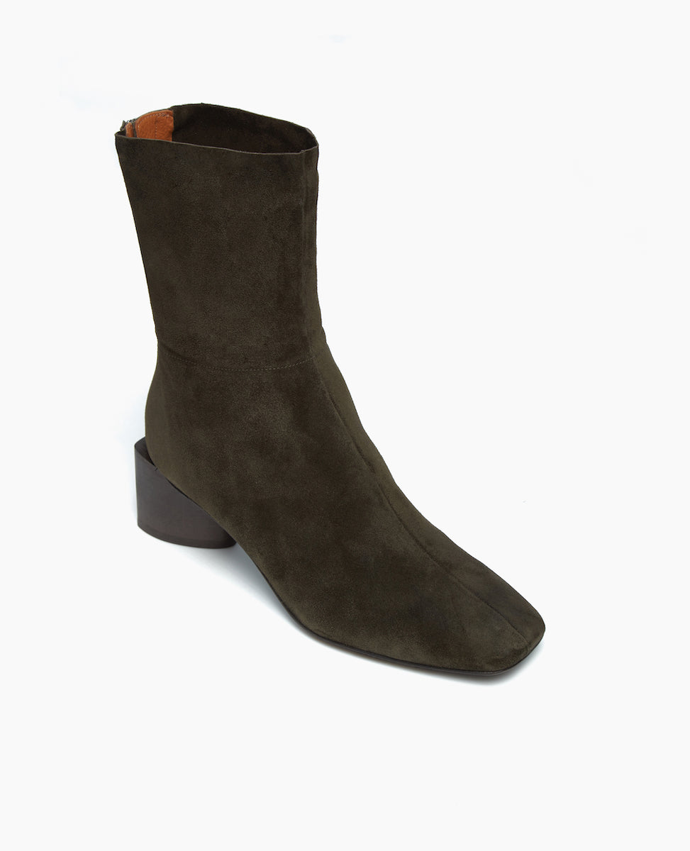 Angled view of the Ida Boot in Mimetico split suede: featuring a modern square toe with a higher shaft and solid wood sculptural block 52mm heel.