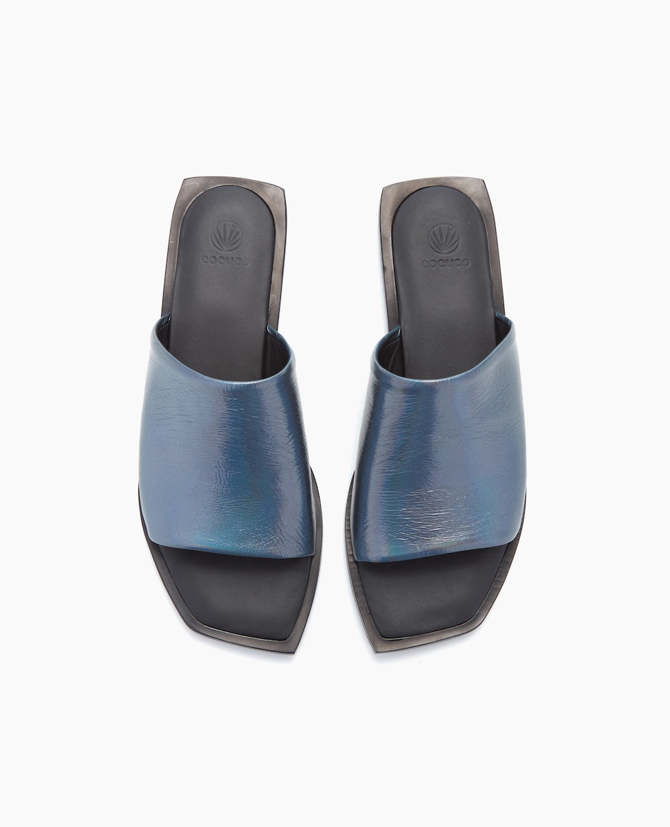 Sleek, open-toed sandals feature a metallic blue leather upper with a wide strap, a black cushioned footbed, and a square toe design.