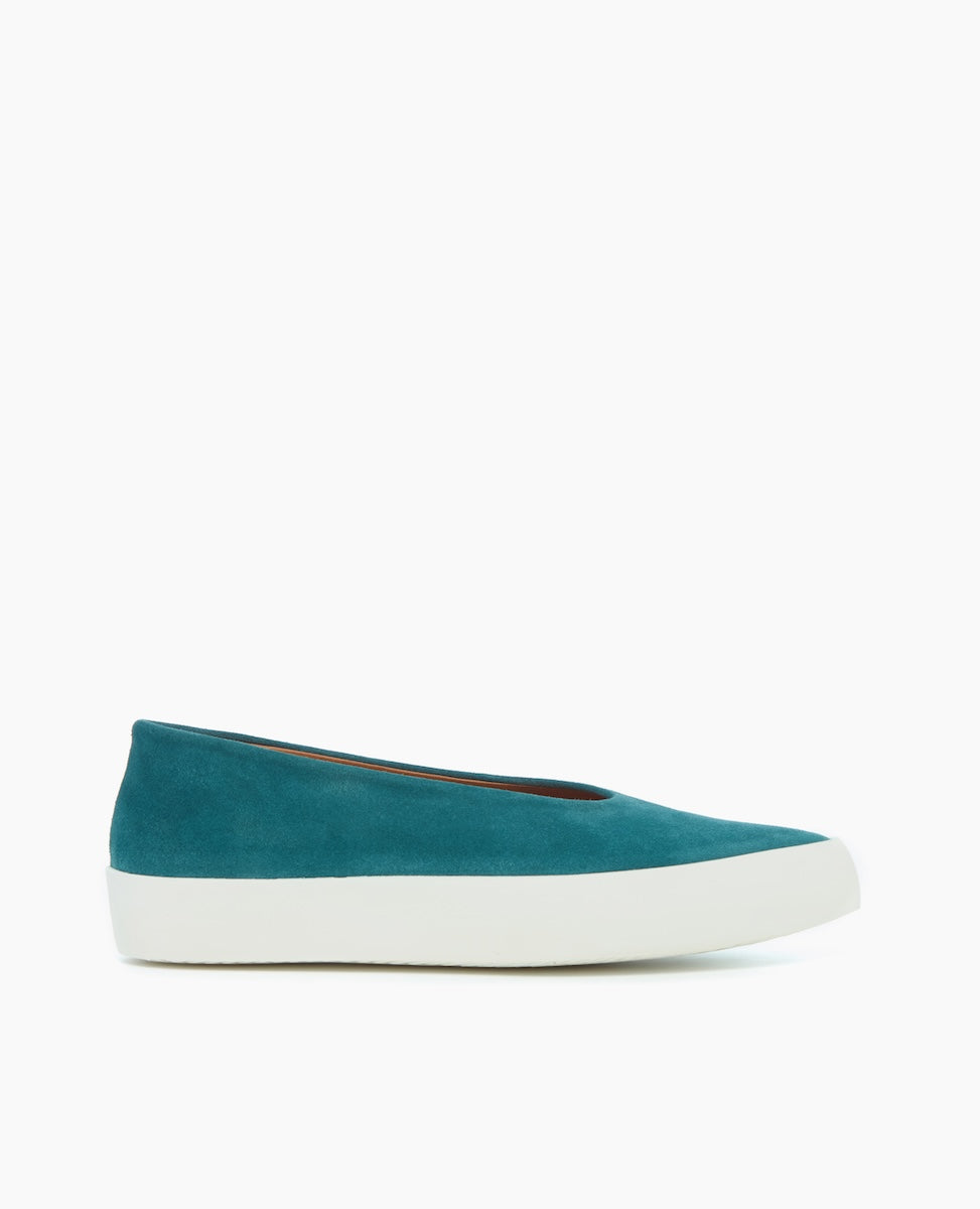 A teal-colored, low-cut slip-on shoe with a smooth suede upper, a rounded toe, and a thick white rubber sole.