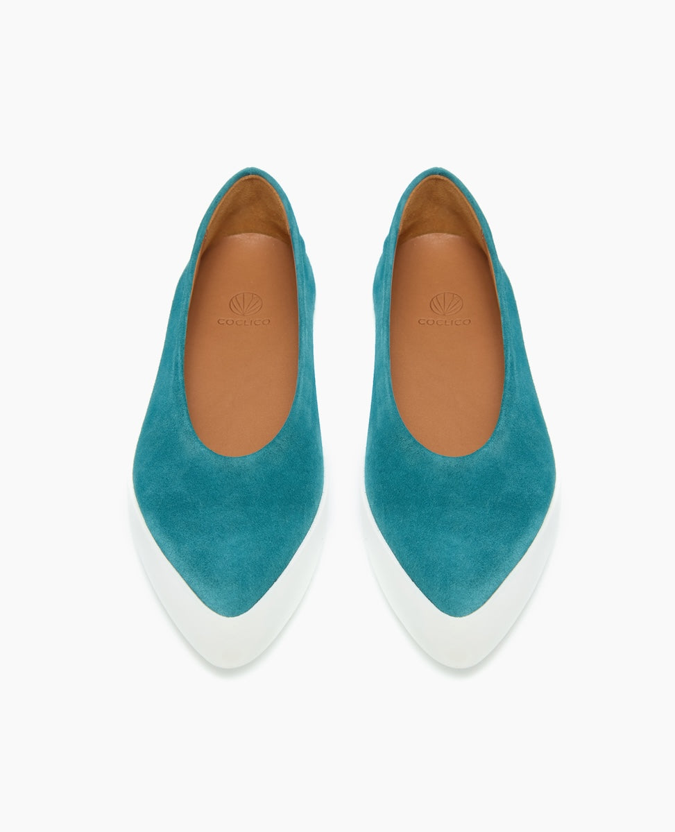 Teal suede ballet flats with a rounded toe, white rubber sole, tan leather interior, and a minimalist design.