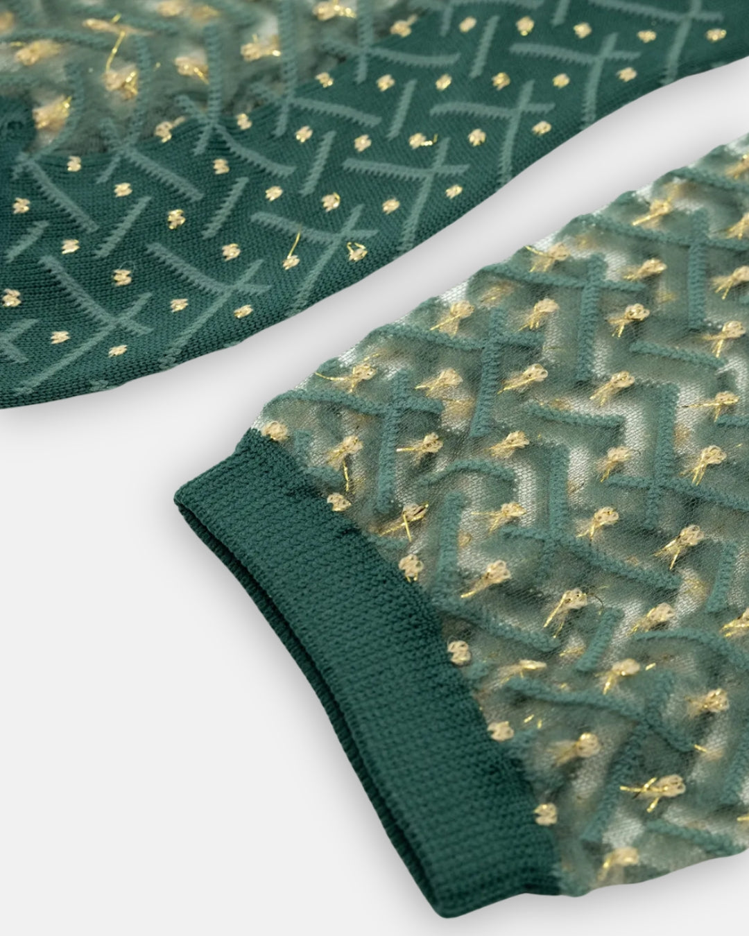 Pair of sheer green Kaktus Emeraude socks with a crisscross pattern and gold flecks, laid flat on a light gray background