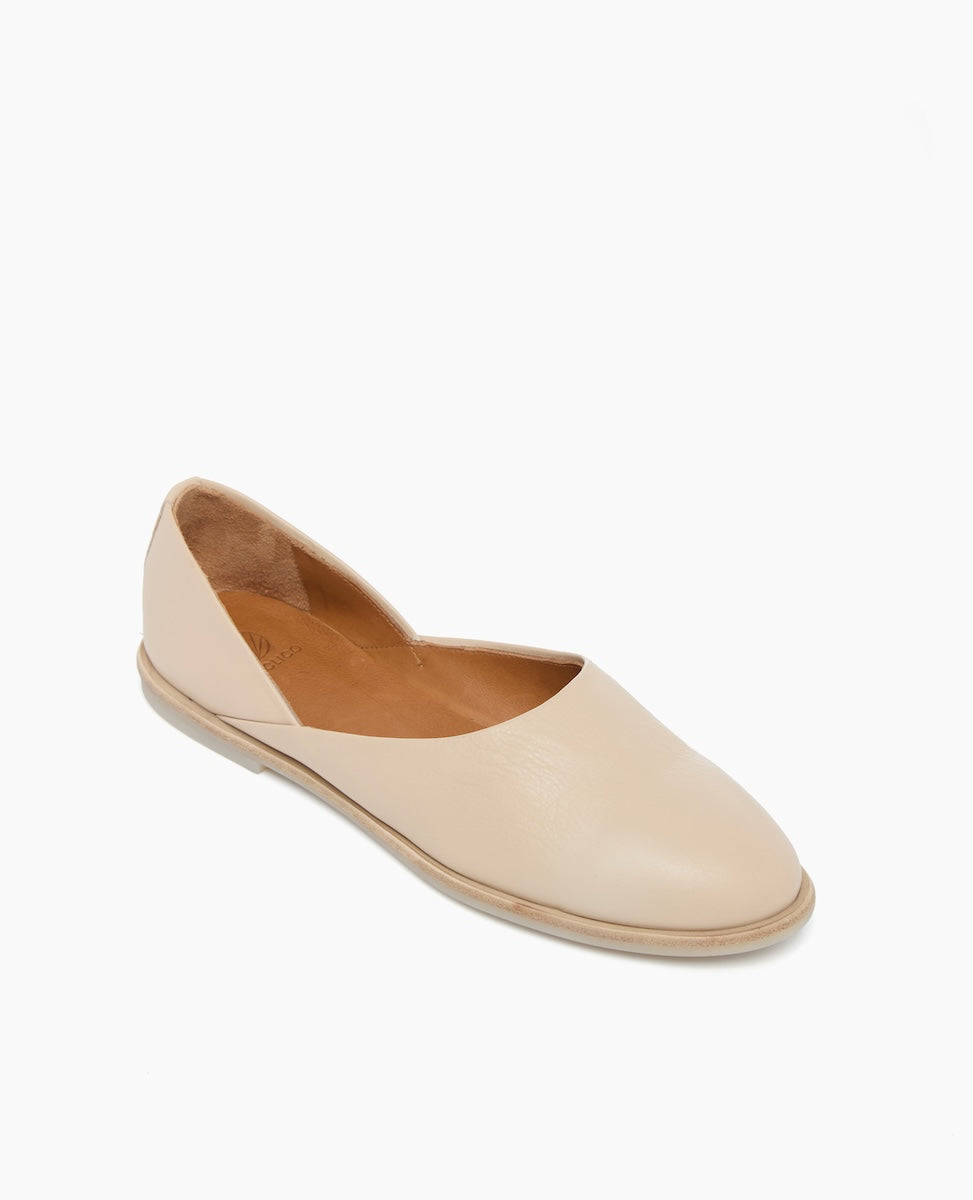 A beige, slip-on flat shoe with a smooth leather finish, almond-shaped toe, and a low-profile sole.