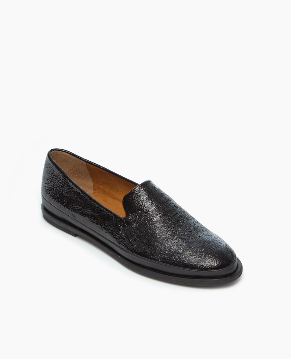 A sleek black leather loafer with a textured finish, smooth rounded toe, low heel, and tan interior lining.