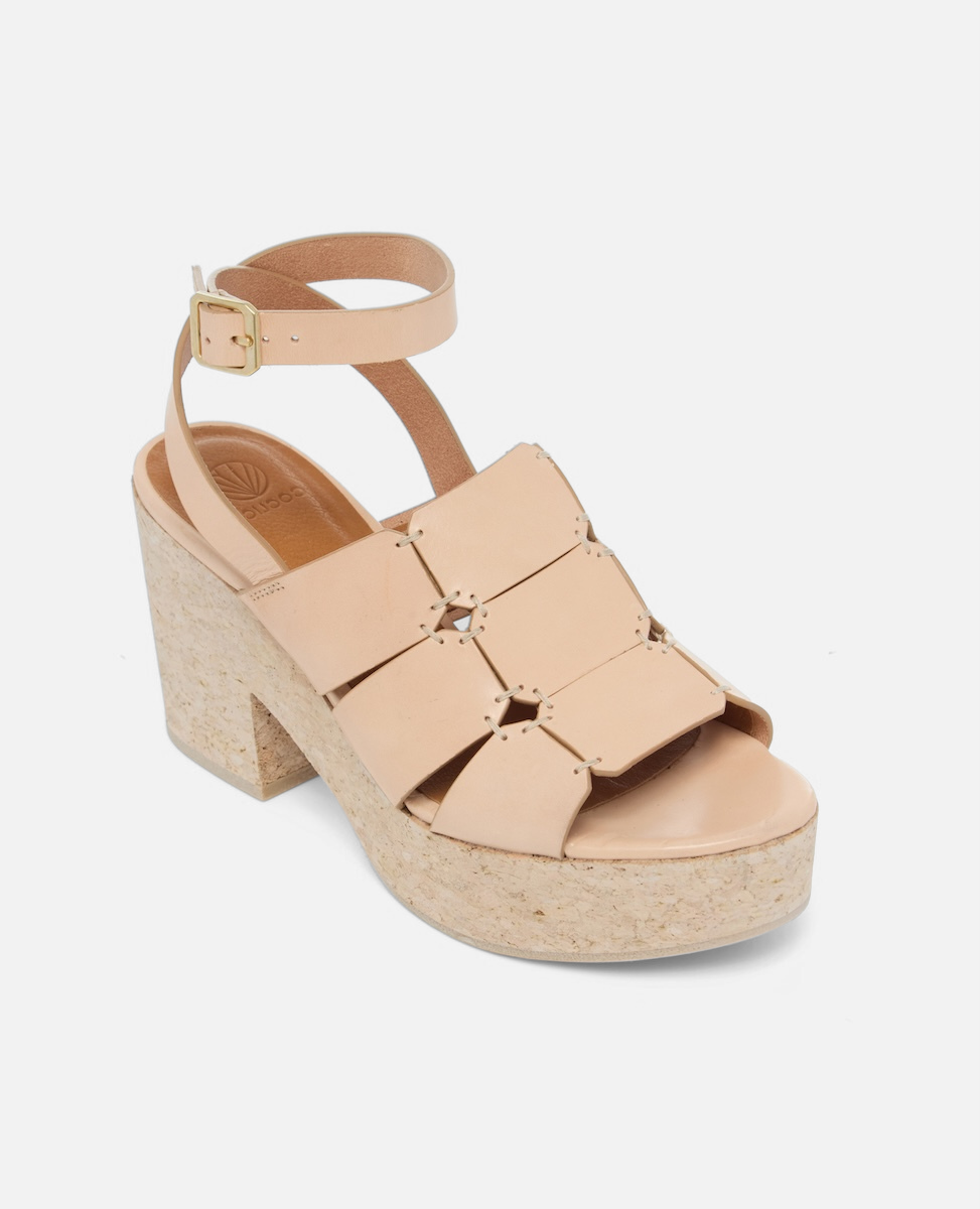 Angled view of a natural vachetta leather platform sandal with octagonal cage straps, hand-stitched detailing, slim ankle strap with buckle, and a solid cork heel and platform, on a white background.