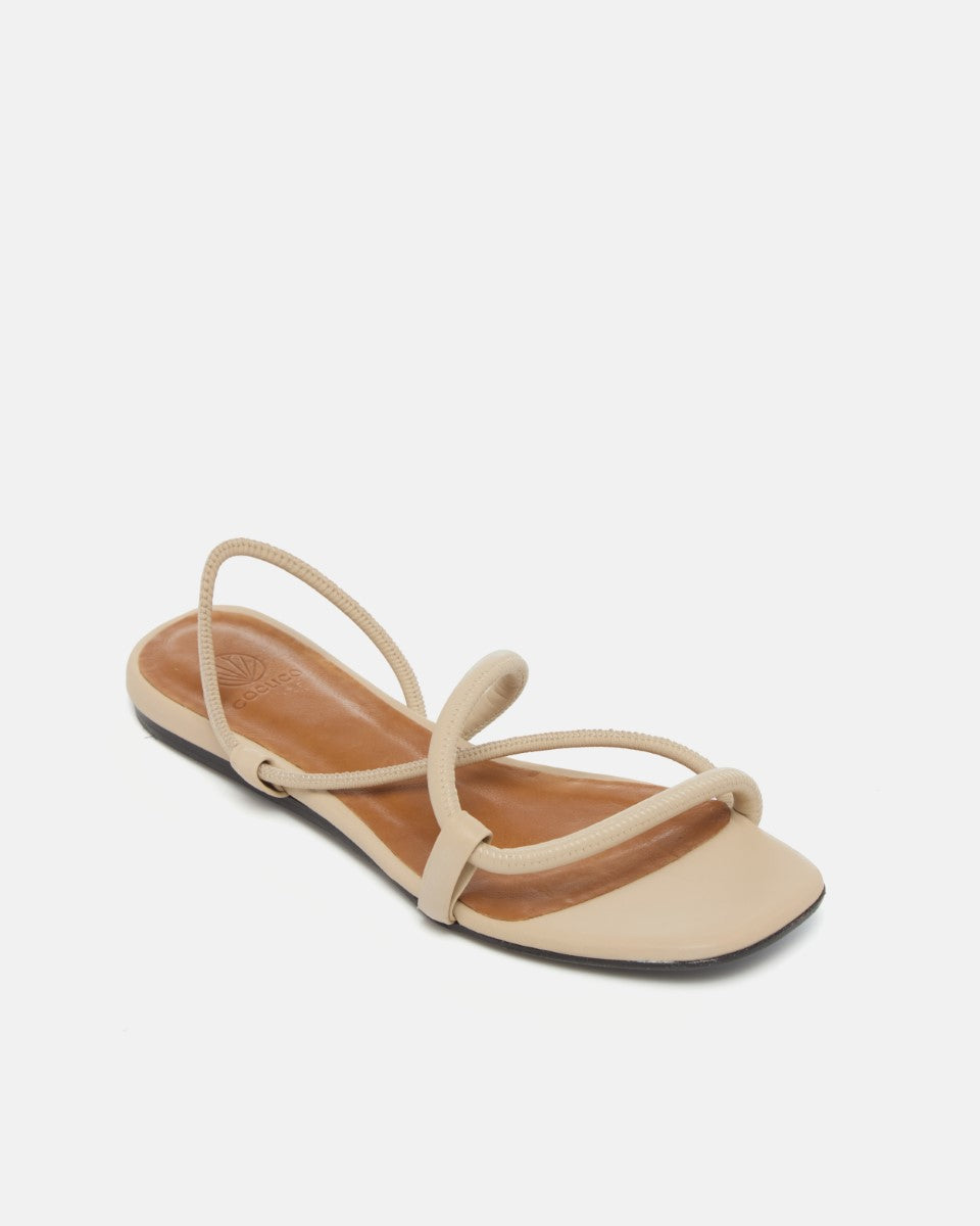 Beige sandal with thin straps on a white background sitting at an angle