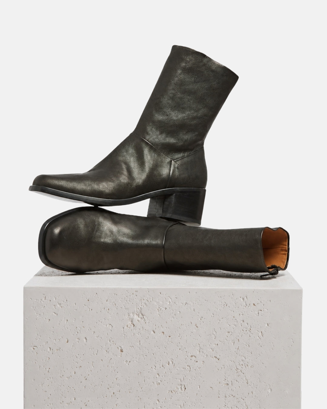 Coclico Black Leather block-heeled boots on a plinth