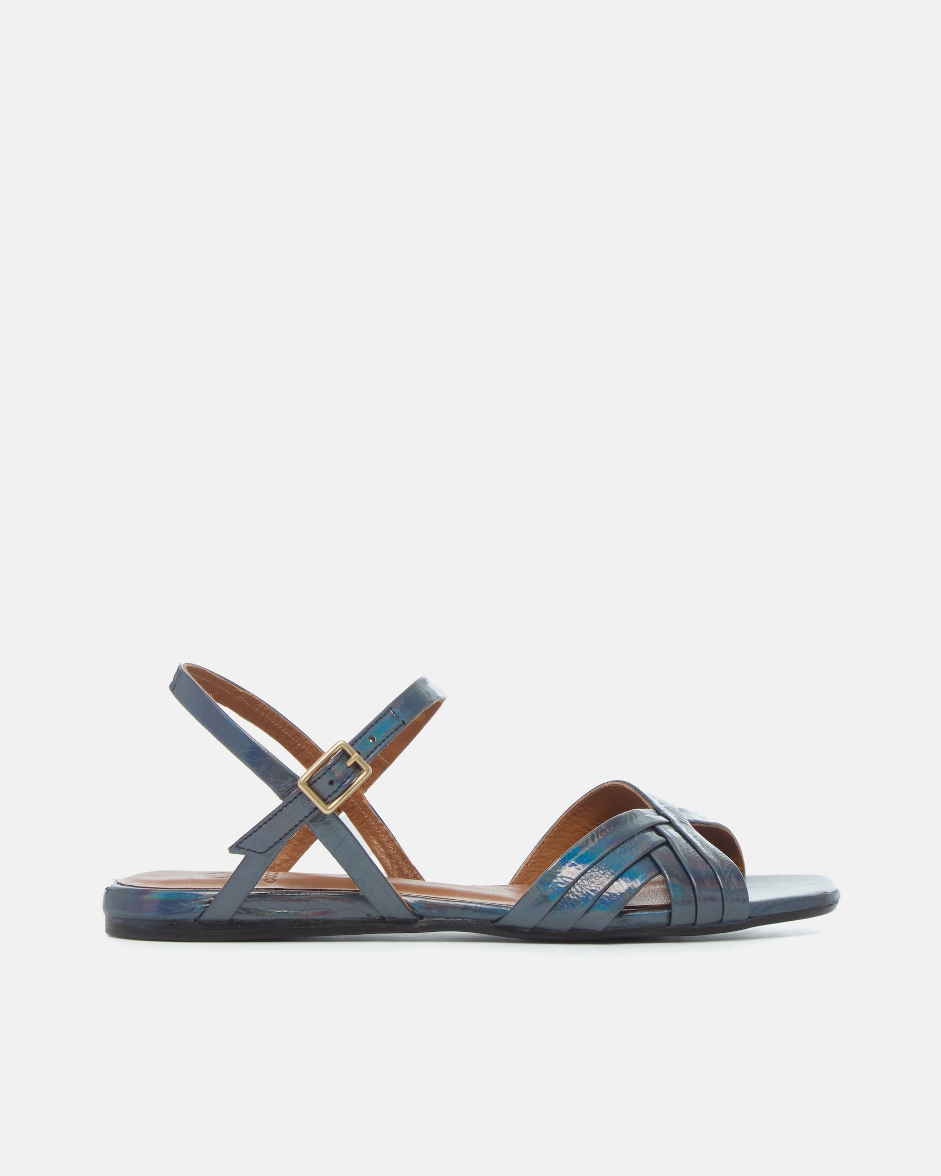 Side view of a deep blue iridescent metallic leather sandal with slim crisscross straps, buckle quarter strap, and a square toe on a white background