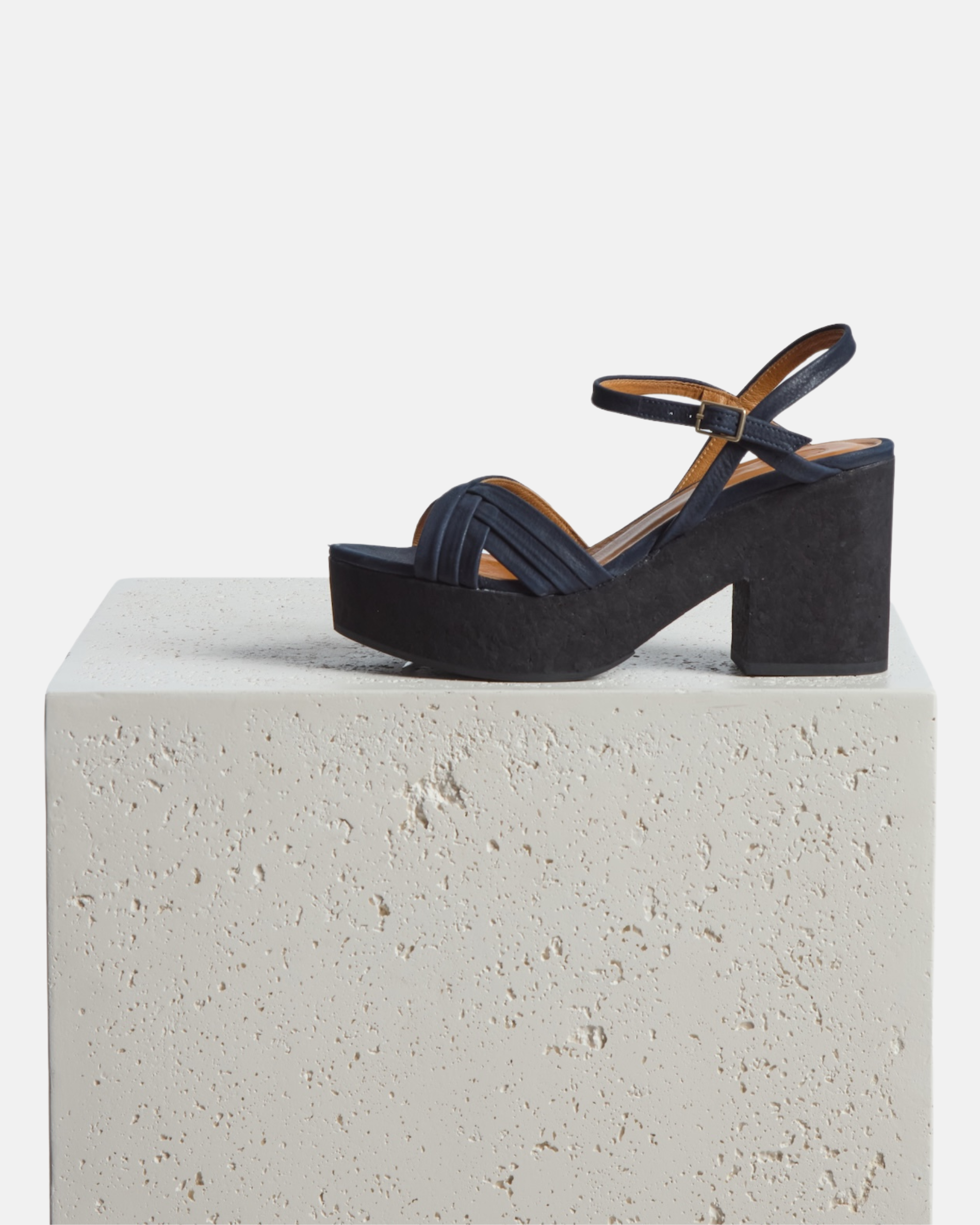 A shoe on a pedestal: navy nubuck leather cork platform sandal with crisscross straps, adjustable ankle strap, and a lightweight cork sole.