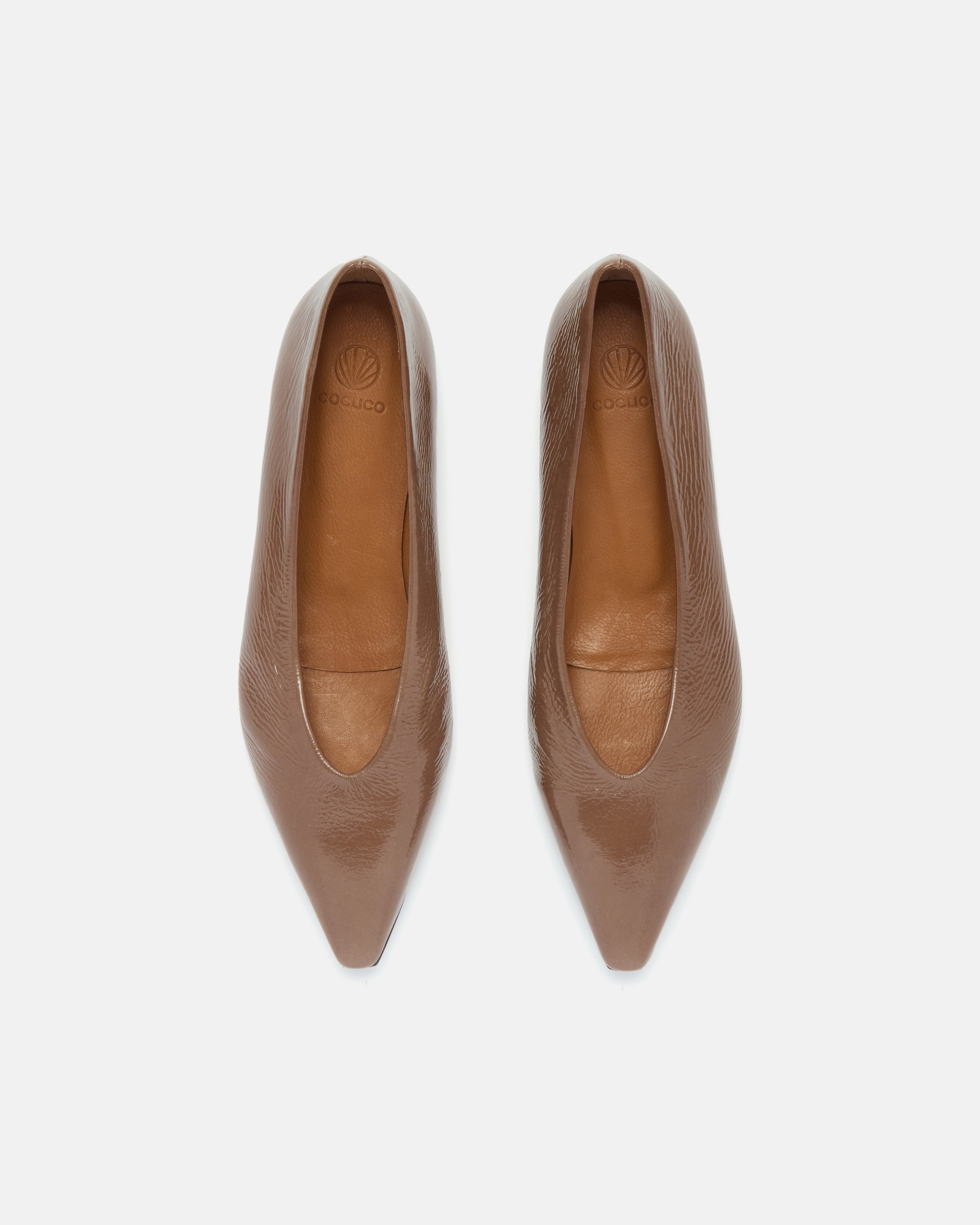 Pair of brown patent leather pointed-toe flat shoe on a light grey background