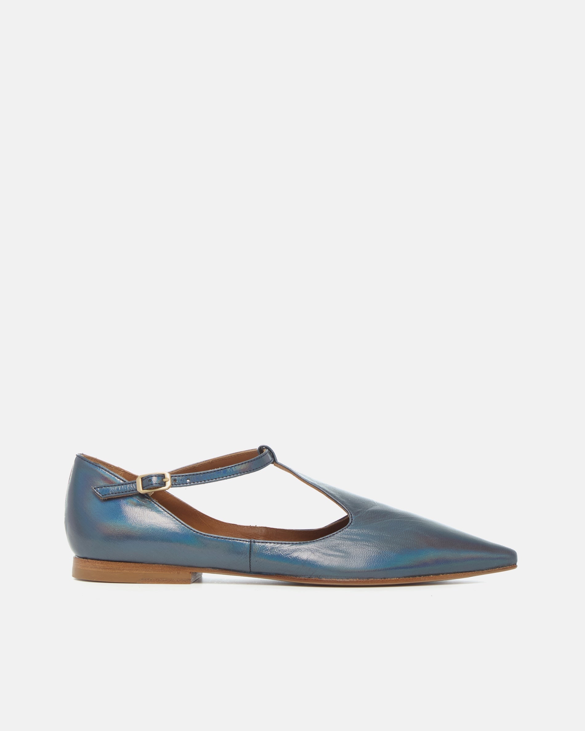 Side view of a pointed-toe iridescent blue metallic T-strap flat with adjustable buckle and leather sole on a white background