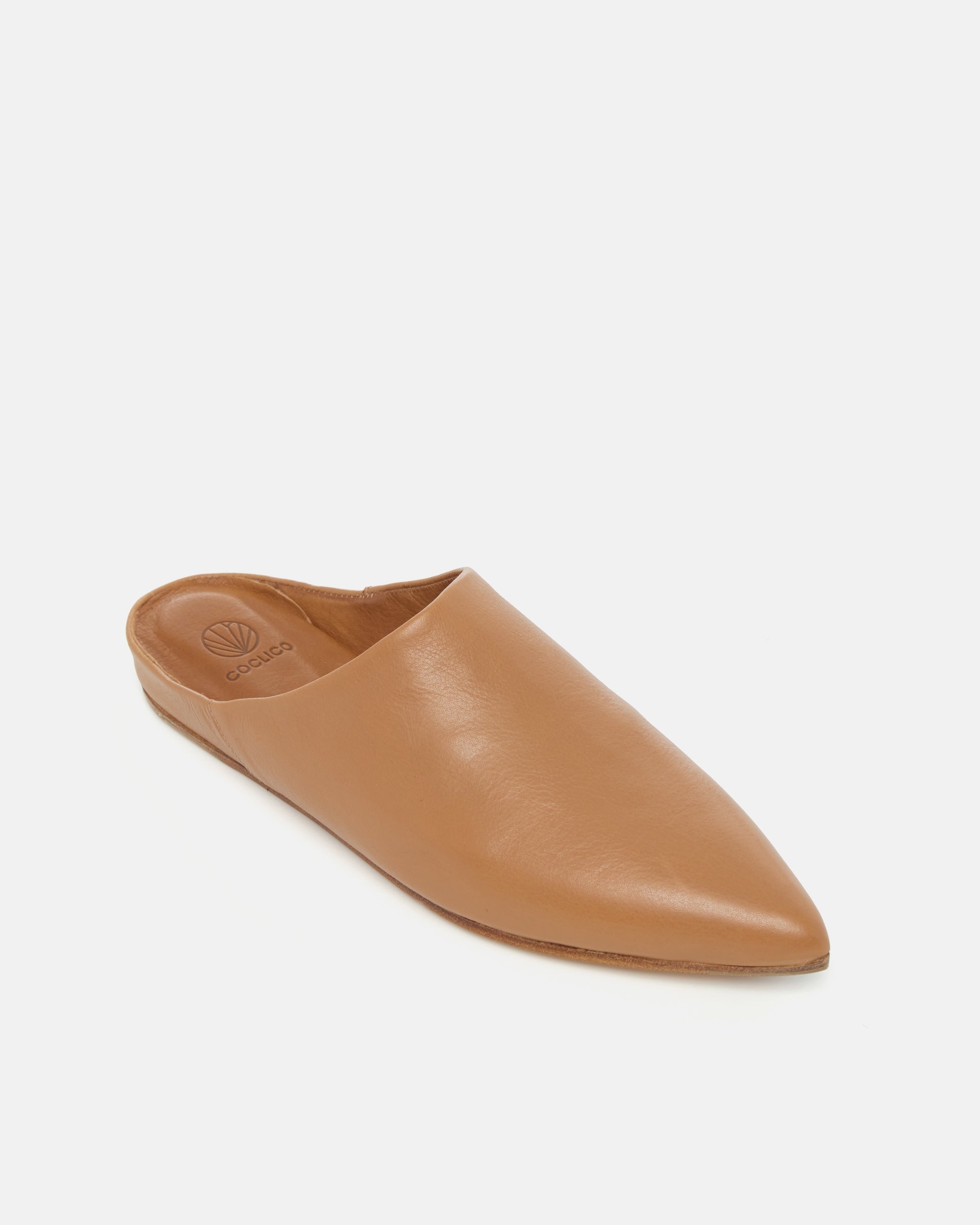 Angled view of a light brown pointed-toe leather mule with a slight built-in wedge and clean minimalist silhouette on a white background