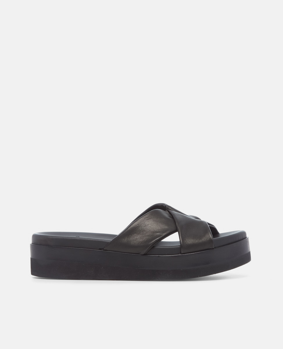 A black platform sandal featuring a thick sole, a smooth leather upper with wide crisscross straps, and an open toe design.