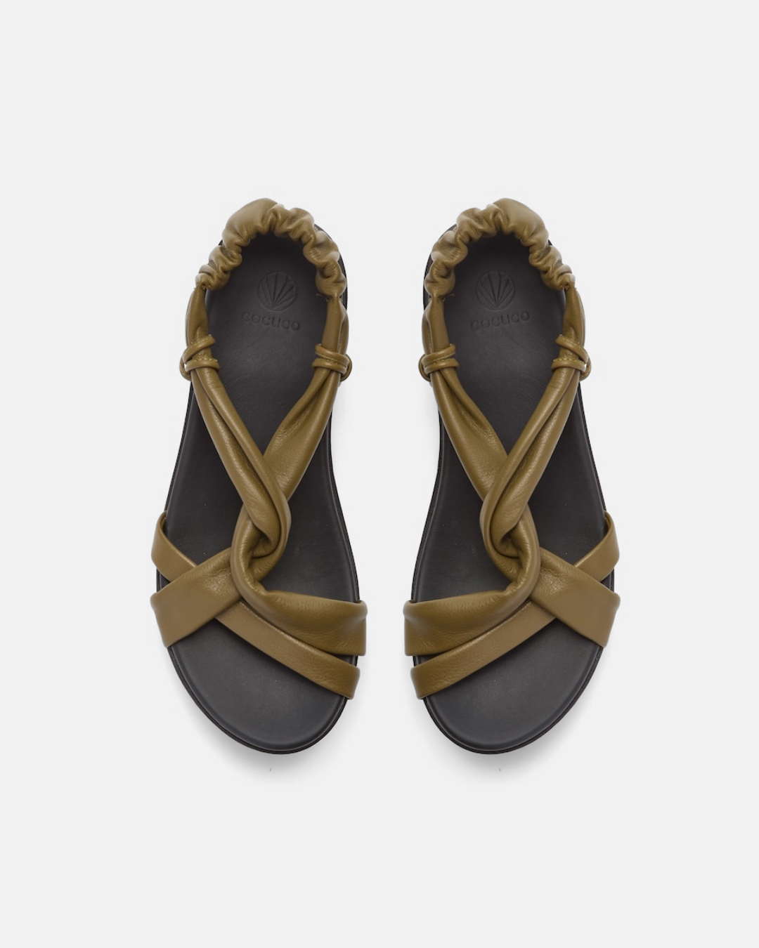 Top view of a sandal featuring a thick black platform sole, olive green leather straps with a crisscross design, and an elasticized back strap for a secure fit.