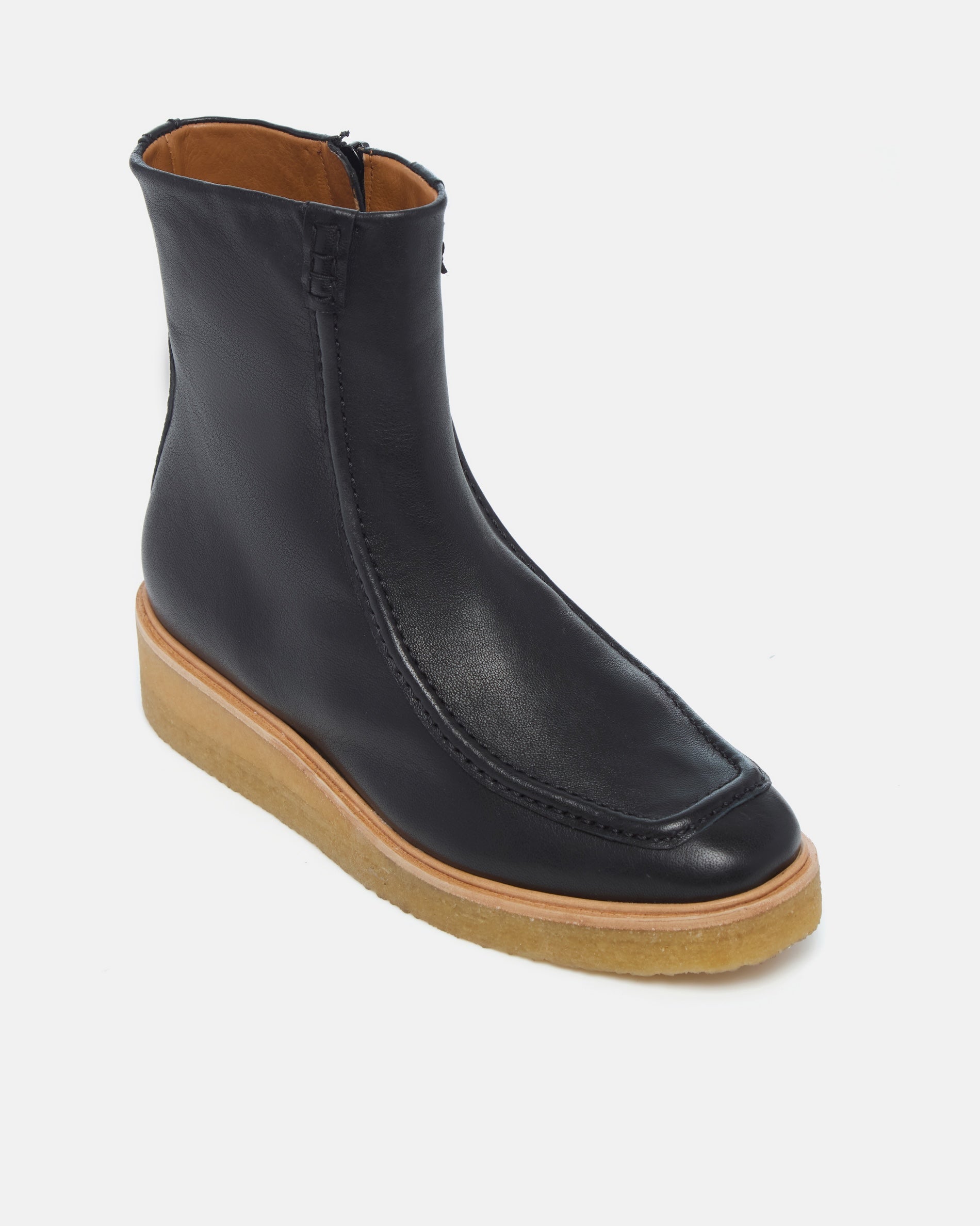 Coclico Haber Boot in black leather, angled view of the front zip and crepe wedge sole
