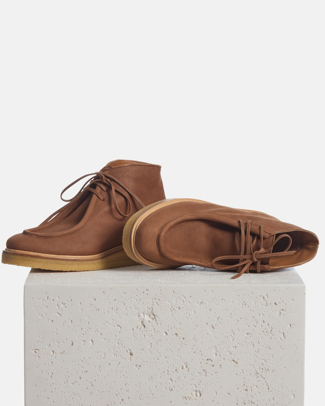 Coclico Hester Boot in Caramello suede, lace up ankle boots with crepe soles styled on a stone plinth