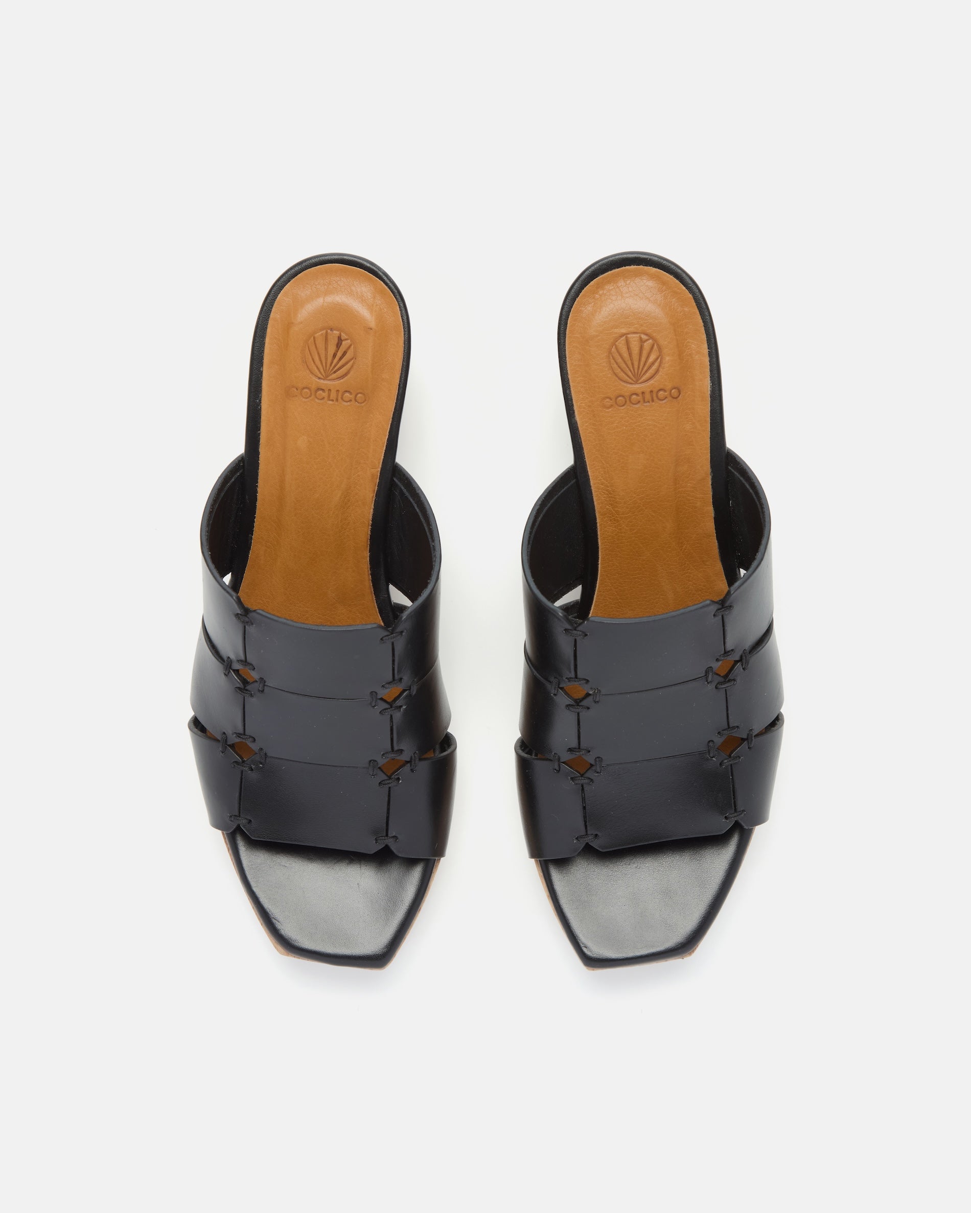 Top view of a clog sandal in black leather featuring linked straps, wooden heel, and open toe slip-on design