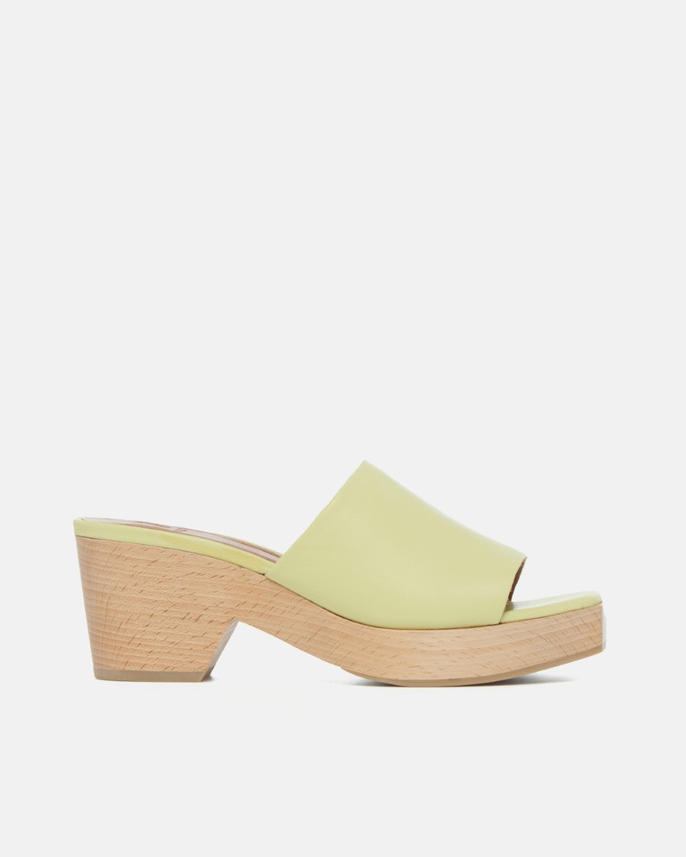Side view of a lemon yellow leather slide clog sandal with a wide upper, squared toe, and solid ash wood sole on a white background.