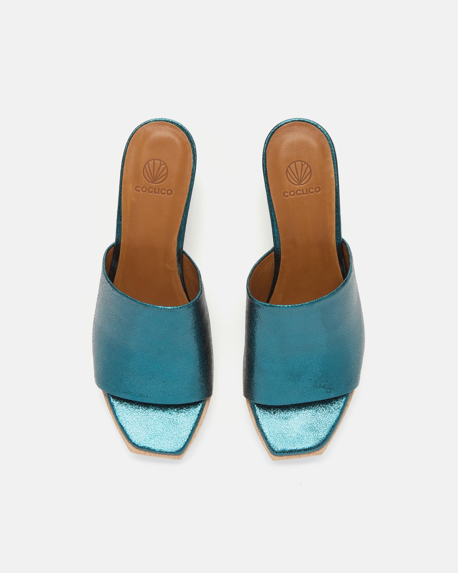 Top view of a metallic blue leather slide clog with a wide upper, squared toe, and solid ash wood sole