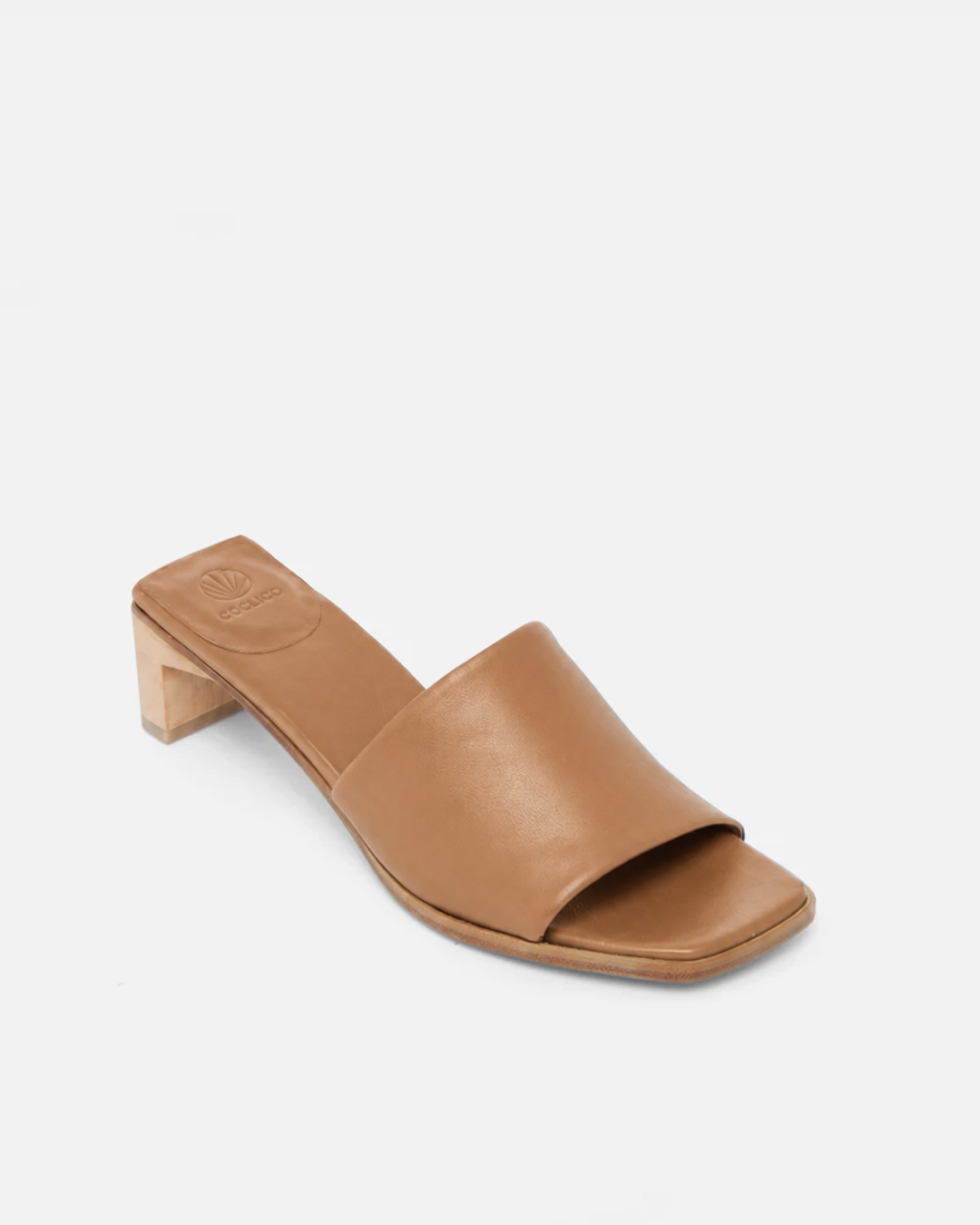 Angled view of a wood mid-heel slide sandal in tan leather