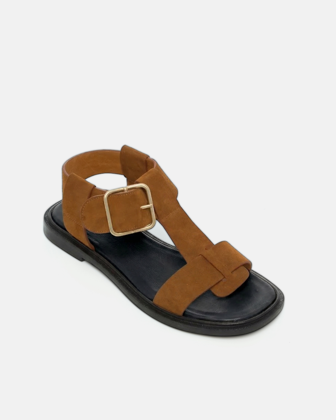 Angled view of a brown suede T-strap sandal with wide straps, oversized buckle, cushioned leather footbed, and substantial sole