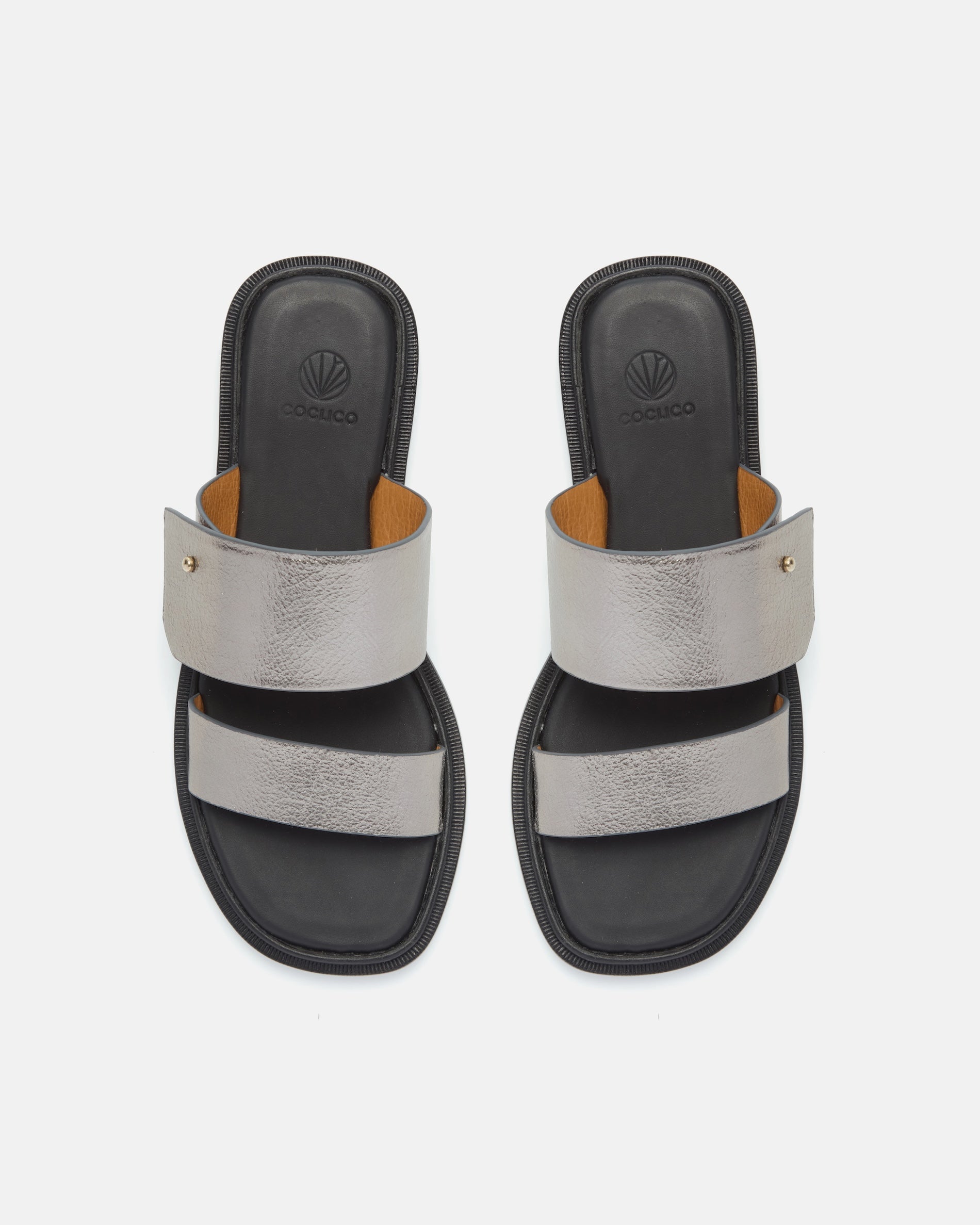 Top view of a pewter metallic leather slide sandal with two wide straps, a subtle metal peg detail, cushioned leather footbed, and flat leather sole